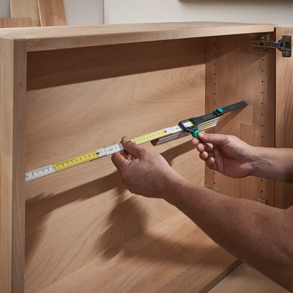 Adaptador colocado en un metro carpintero, facilitando la medición del ancho interior de un mueble