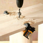 Dos piezas de madera siendo sujetadas por dos prensas esquineras wolfcraft mientras se perforan con un taladro
