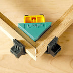 Una prensa wolfcraft en primer plano, sujetando y uniendo dos piezas de madera en un ángulo de 90 grados