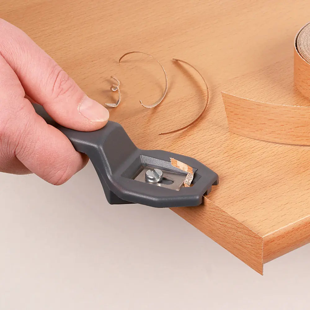 En primer plano el cortador siendo utilizado para cortar el sobrante de los cantos de melamina